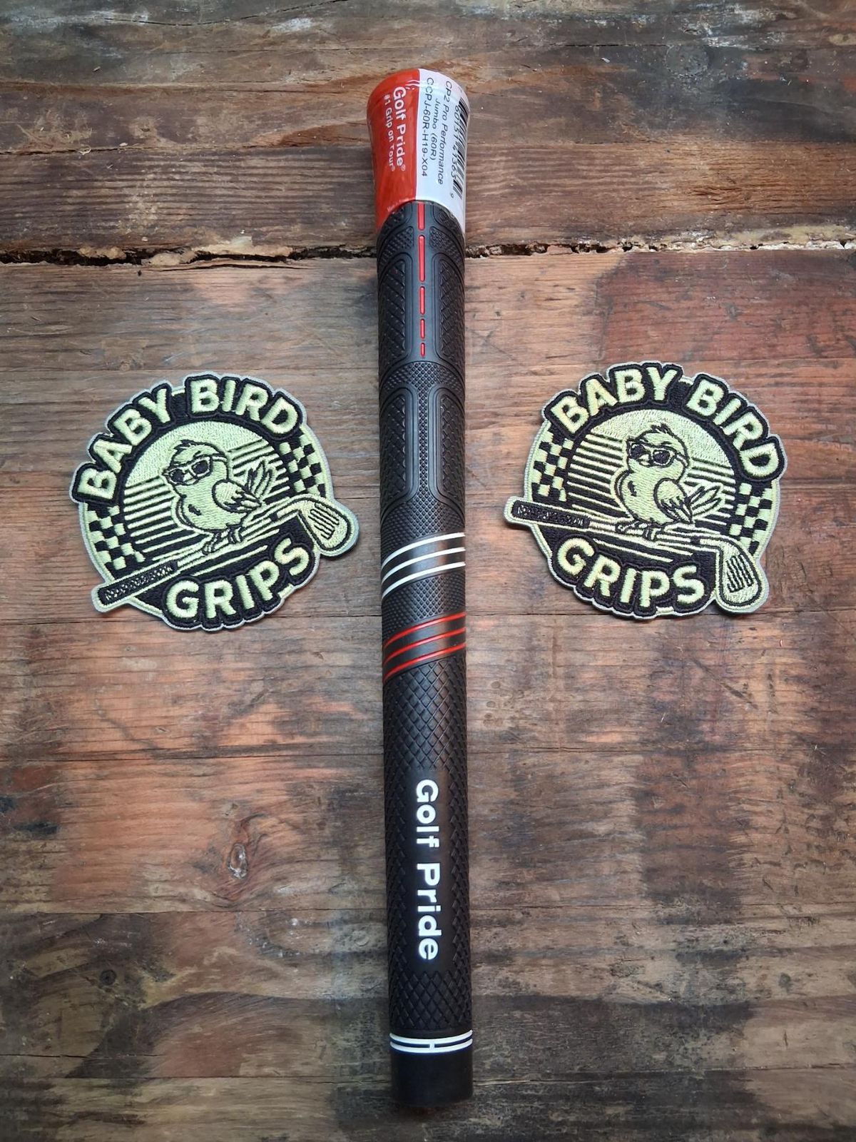 A black Golf Pride CP2 Pro jumbo grip with red accent lines and a red cap