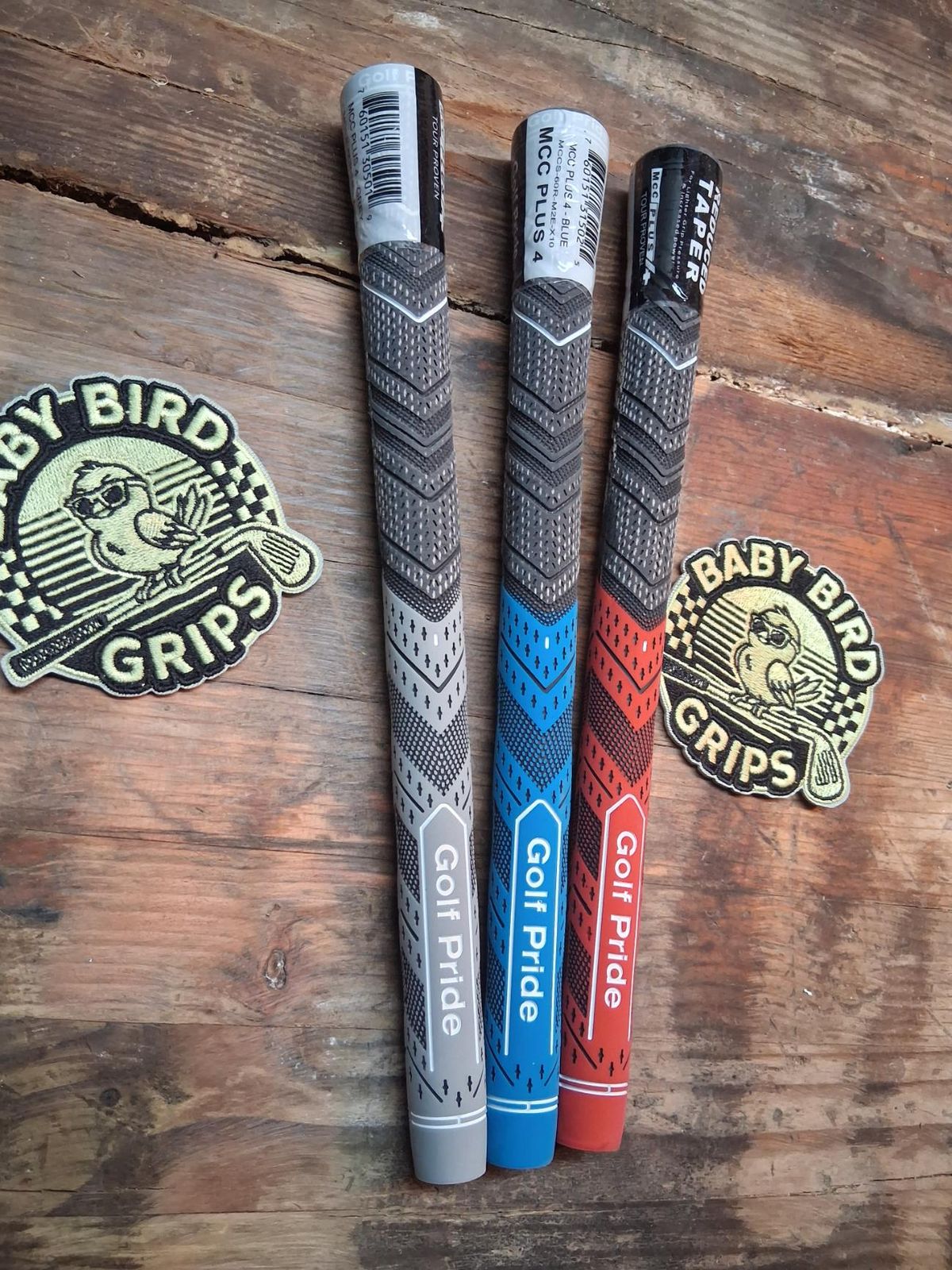 Three Golf Pride MCC Plus 4 grips in gray, blue, and red